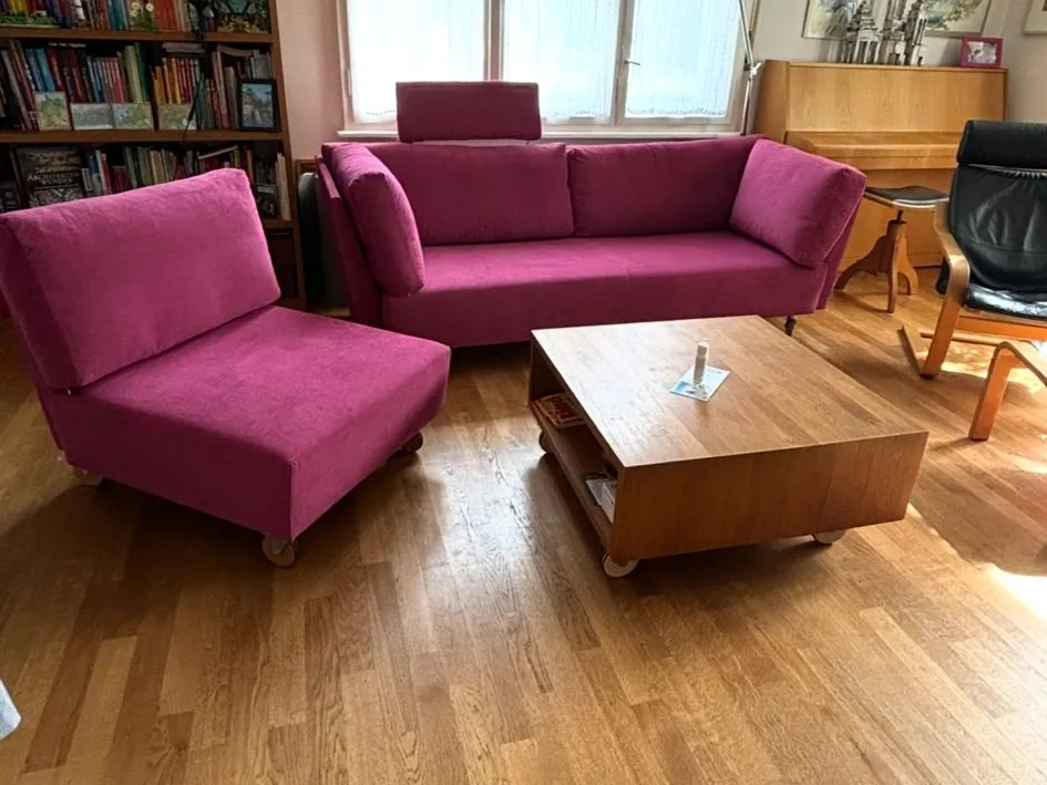 Neu bezogenes Sofa und Sessel in Magenta im Wohnzimmer